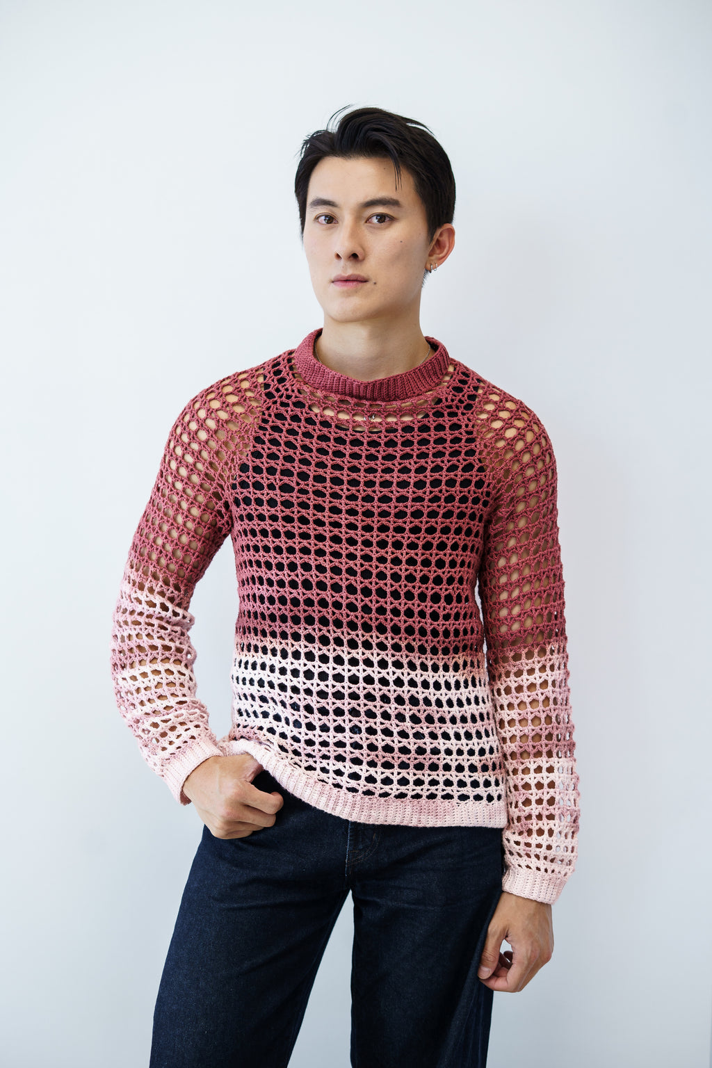 Man wearing a lace crochet sweater against a plain background