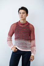 Man wearing a lace crochet sweater against a plain background